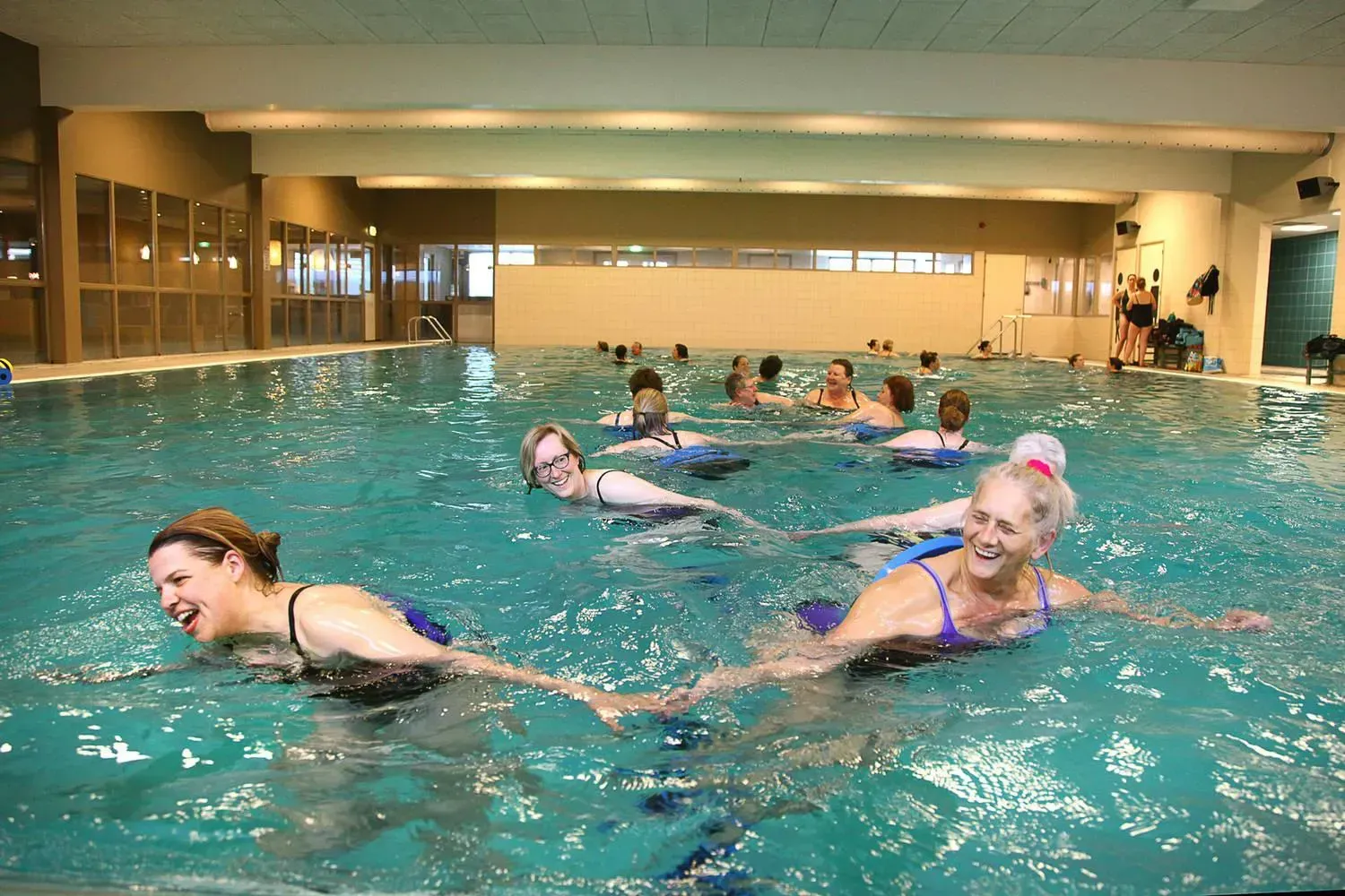 lachende vrouwen in zwembad tijdens Aqua Zumba