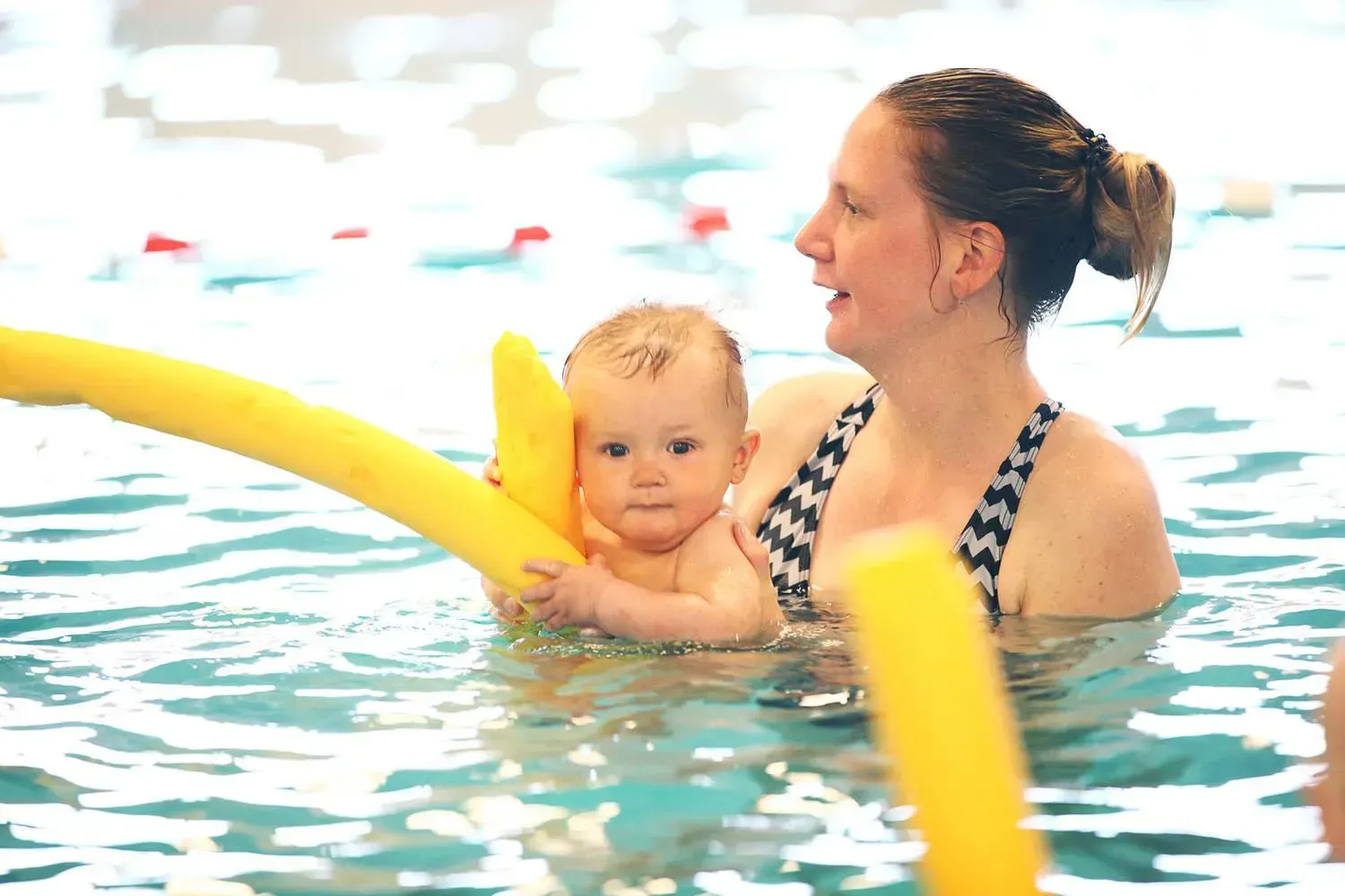 lachende moeder met kind in het zwembad